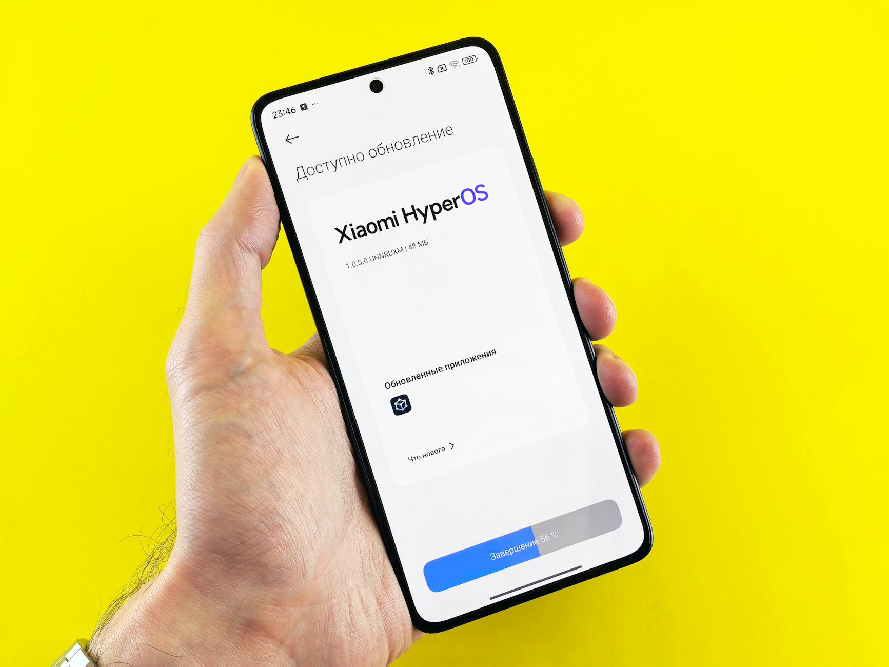 Dłoń trzymająca smartfon z ekranem aktualizacji Xiaomi HyperOS