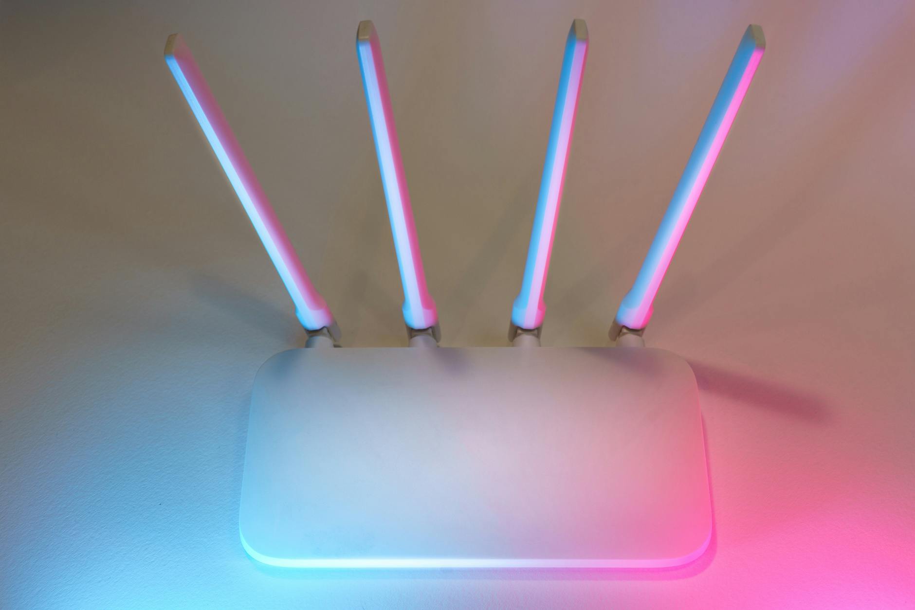 Nowoczesny biały router Wi‑Fi 7 z czterema antenami w kolorowym świetle