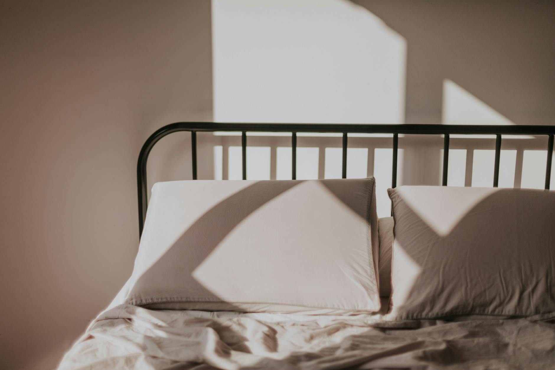 Poranna pościel w słońcu, geometryczne cienie tworzą spokojny nastrój