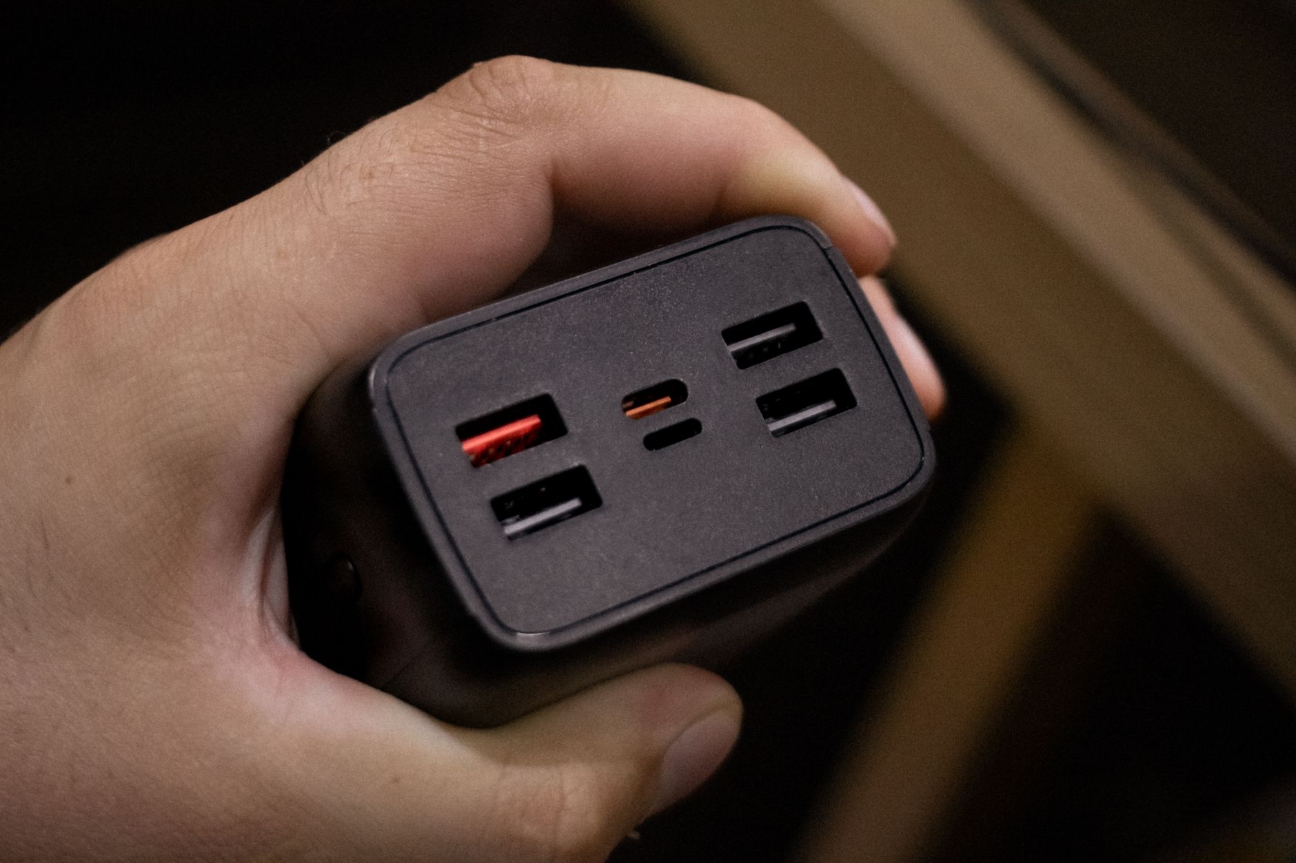 Dłoń trzymająca powerbank z kilkoma portami USB zbliżenie