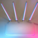 Nowoczesny biały router Wi Fi z czterema antenami w niebiesko różowym świetle