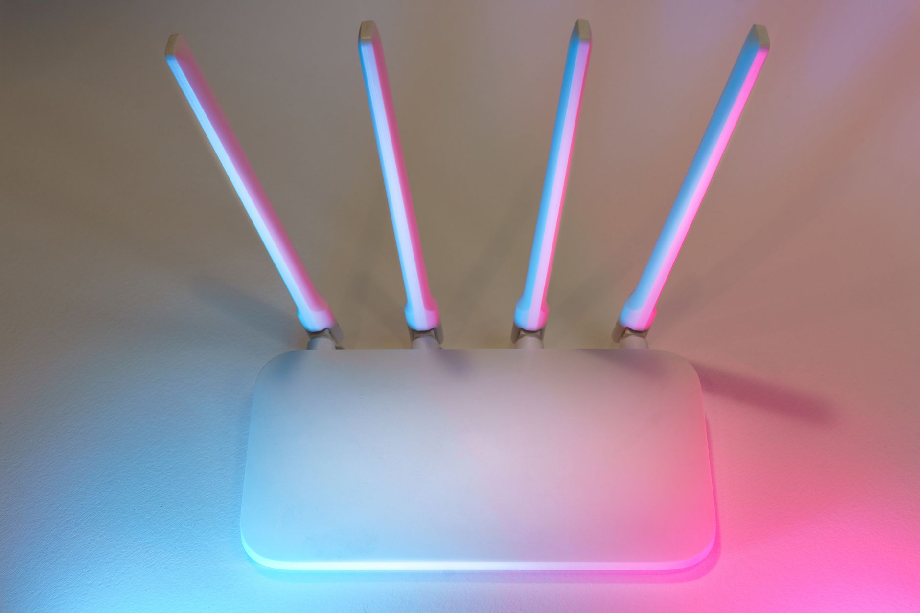 Nowoczesny biały router Wi Fi z czterema antenami w niebiesko różowym świetle