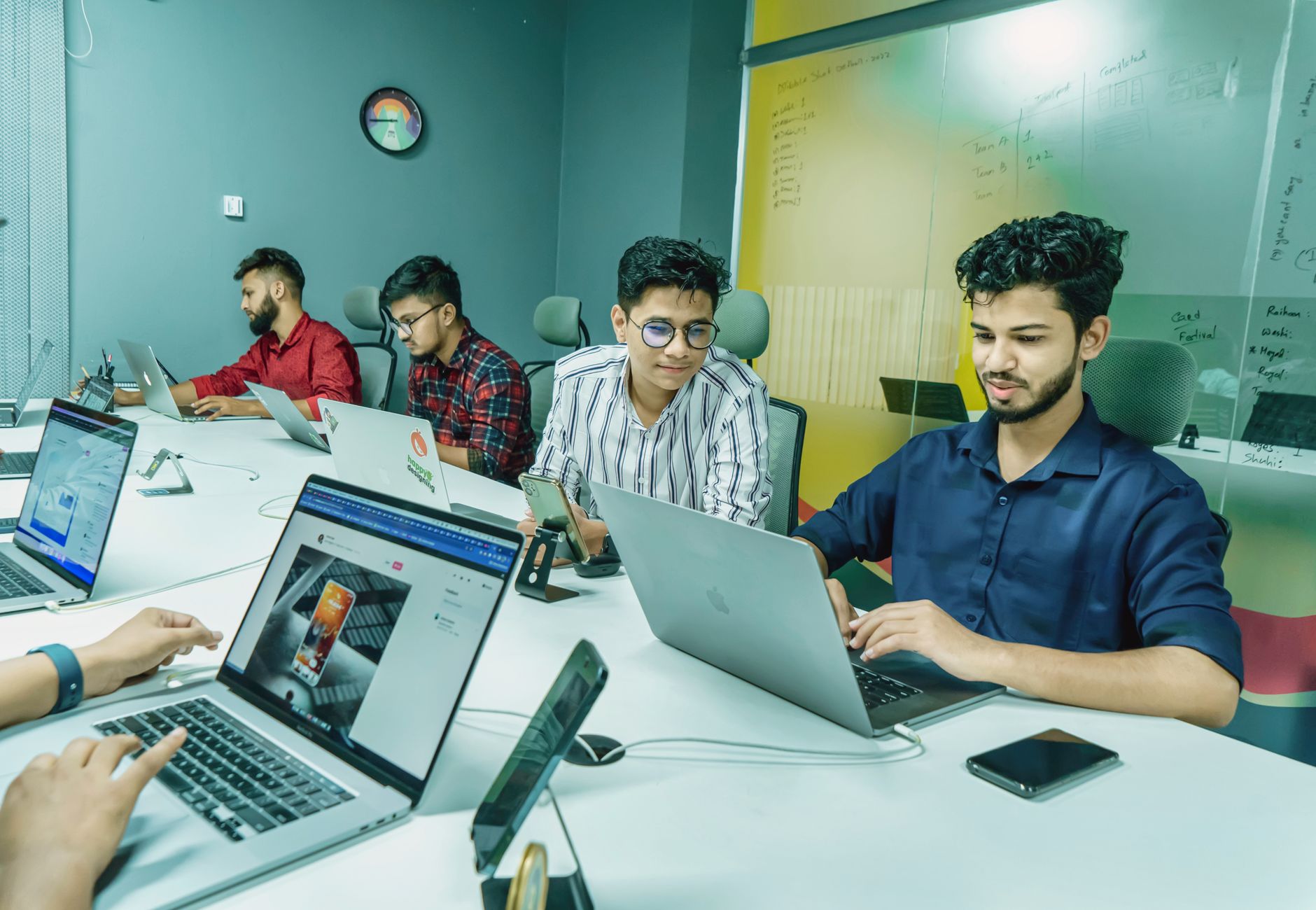 Zespół specjalistów IT omawia projekt open source przy laptopach