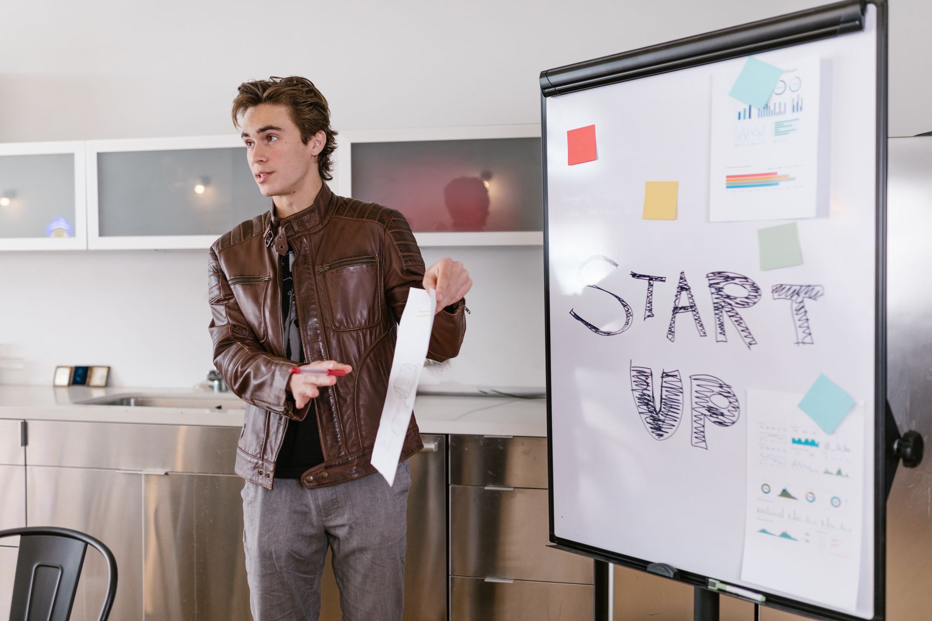 Młody przedsiębiorca prezentuje strategię startupu SaaS przy flipcharcie