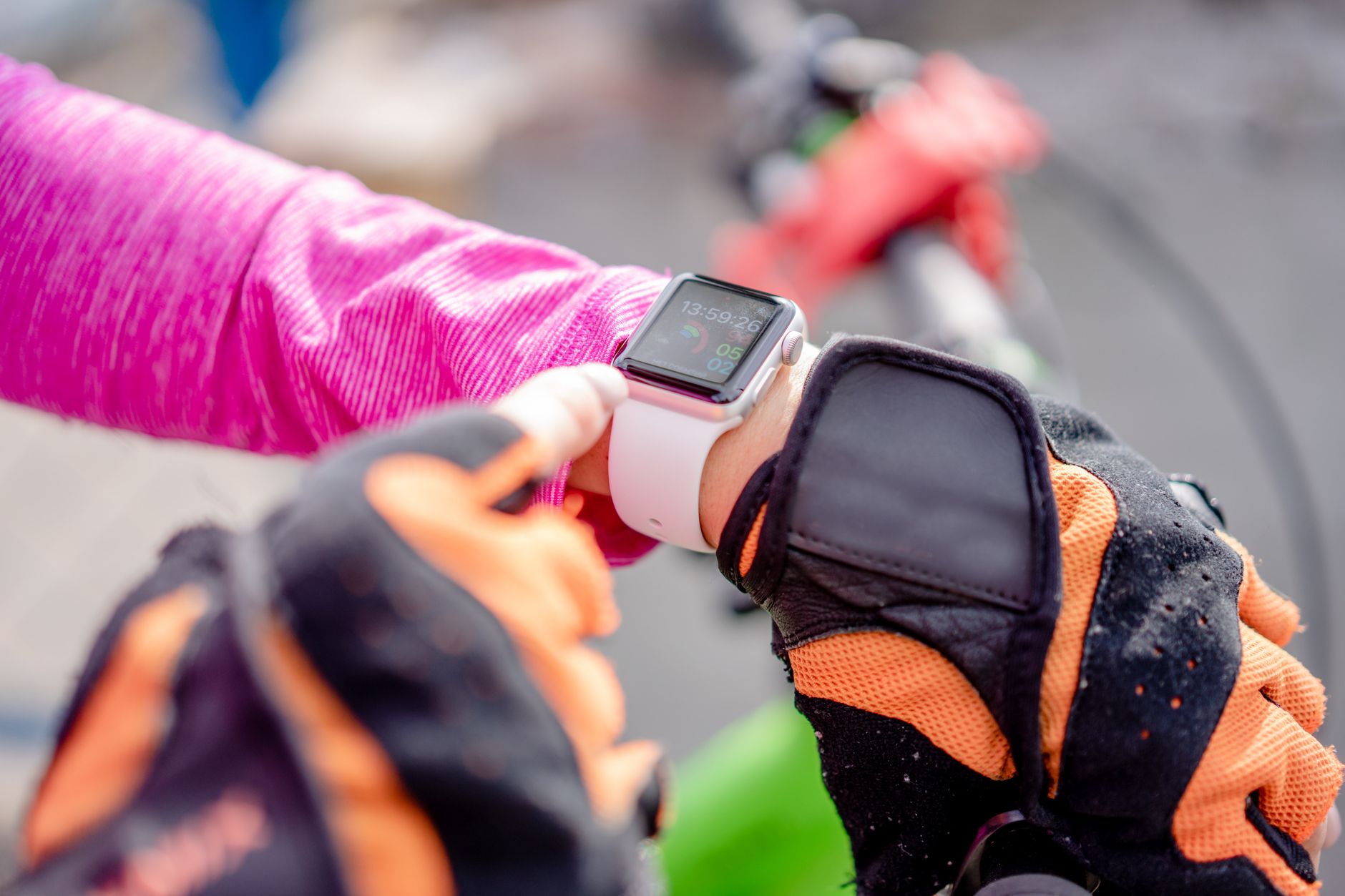 Rowerzysta w rękawiczkach sprawdza smartwatch na zewnątrz