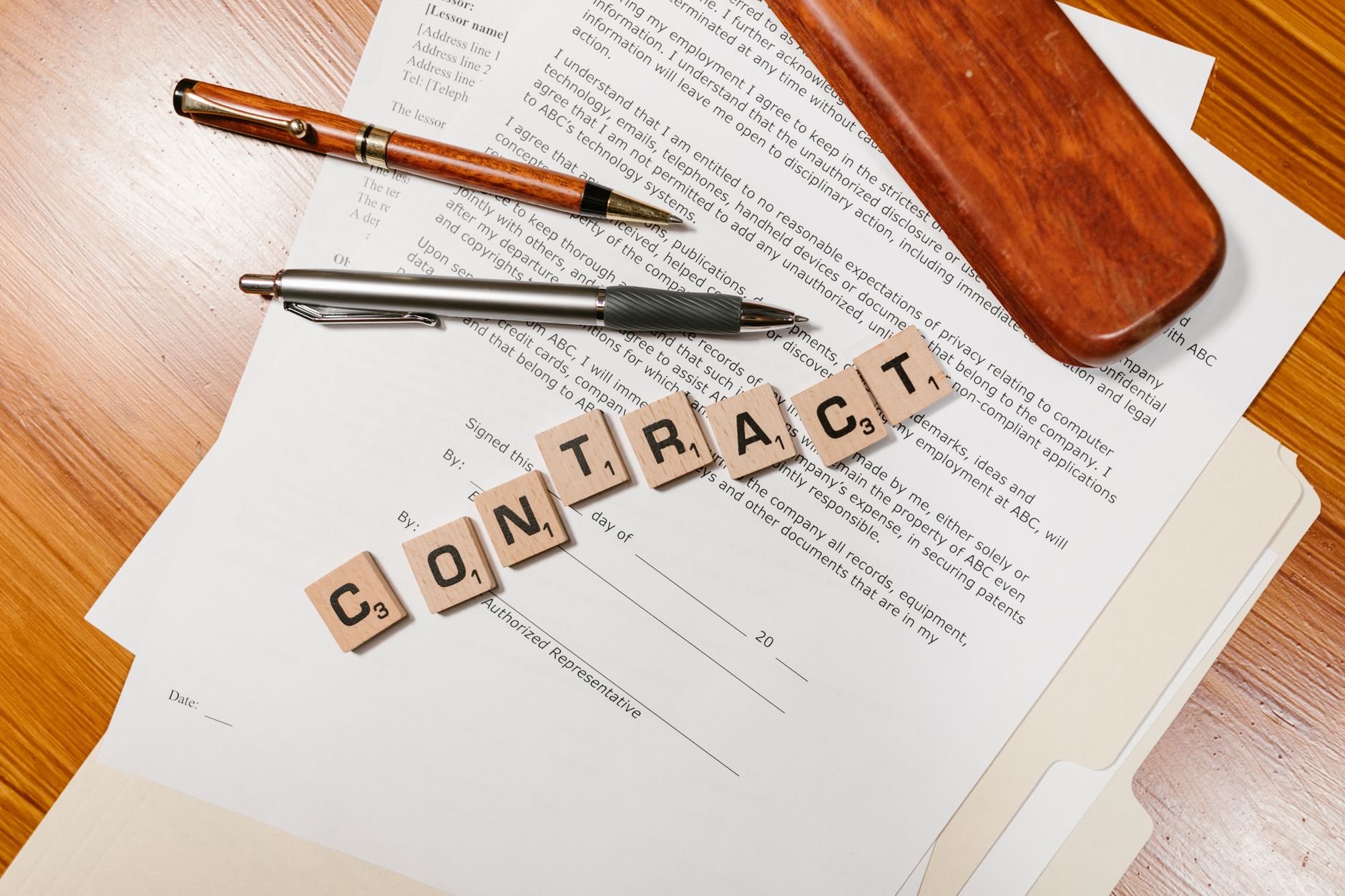 Zbliżenie na dokumenty umowy i litery układające słowo CONTRACT